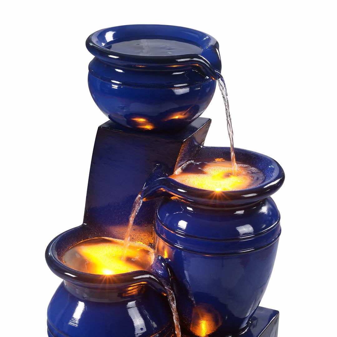 The top three tiers of a navy blue pot water fountain stacked on pedestals