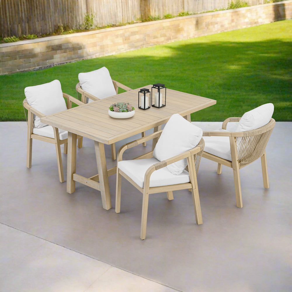Outdoor patio dining set with light wood table and four cushioned rope chairs on concrete.