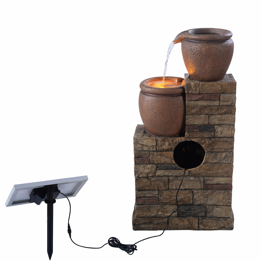 A view from behind of the fountain featuring where the pump is inserted inside and the lead to the solar panel