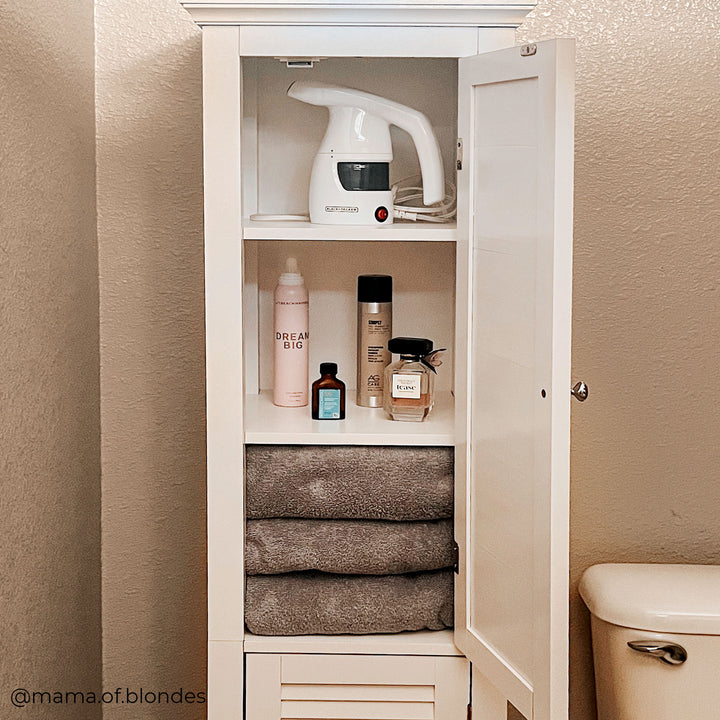 A tall white linen cabinet with the door open and items on the shelves inside