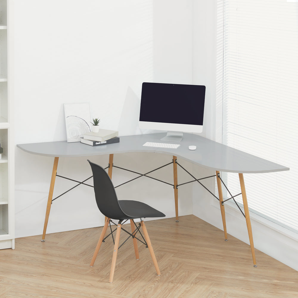 A black chair sat behind an L-shaped computer desk in a white room