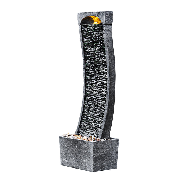 Sideview of a black wavy waterfall style water fountain and base with pebbles