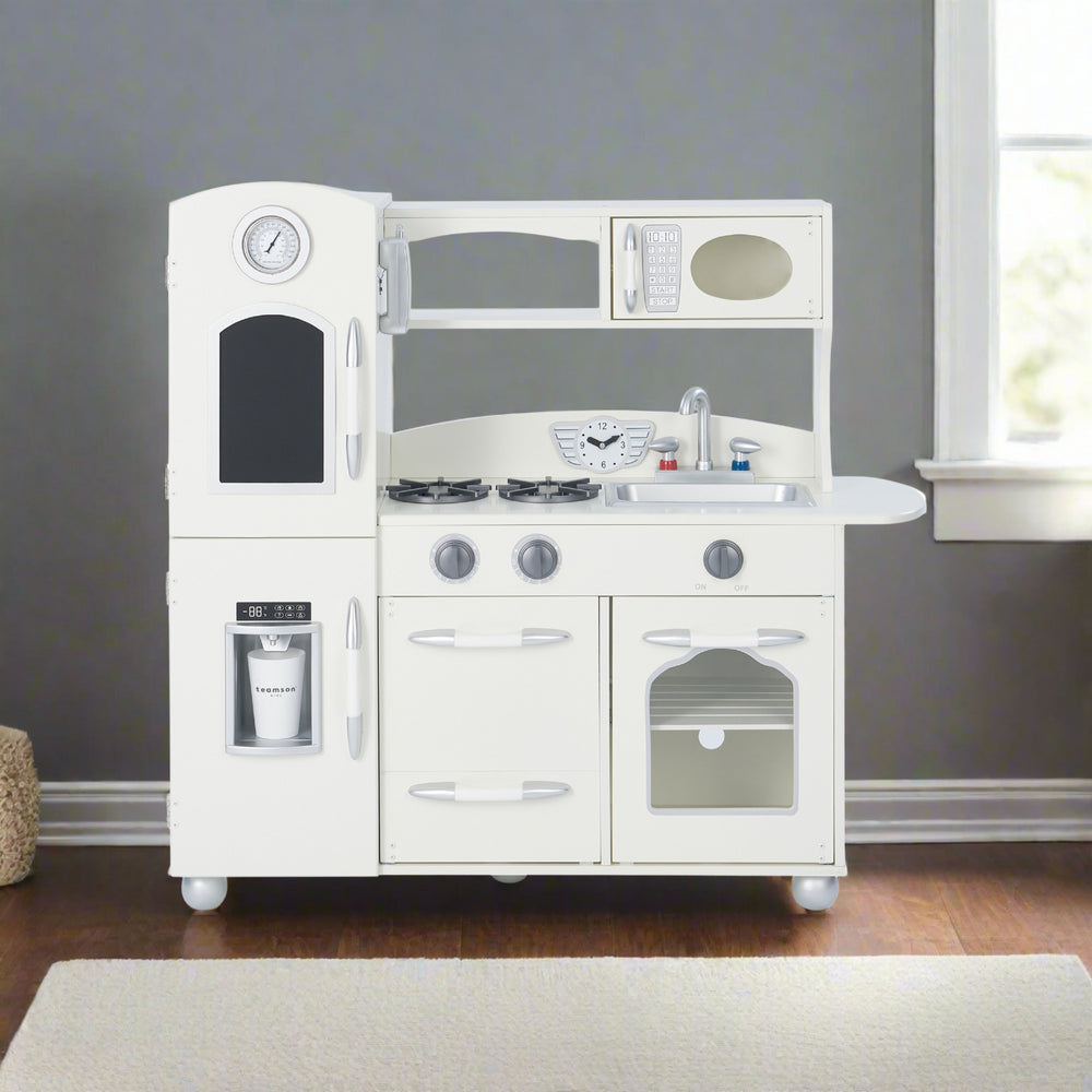 A white play kitchen with silver hardware against a gray wall